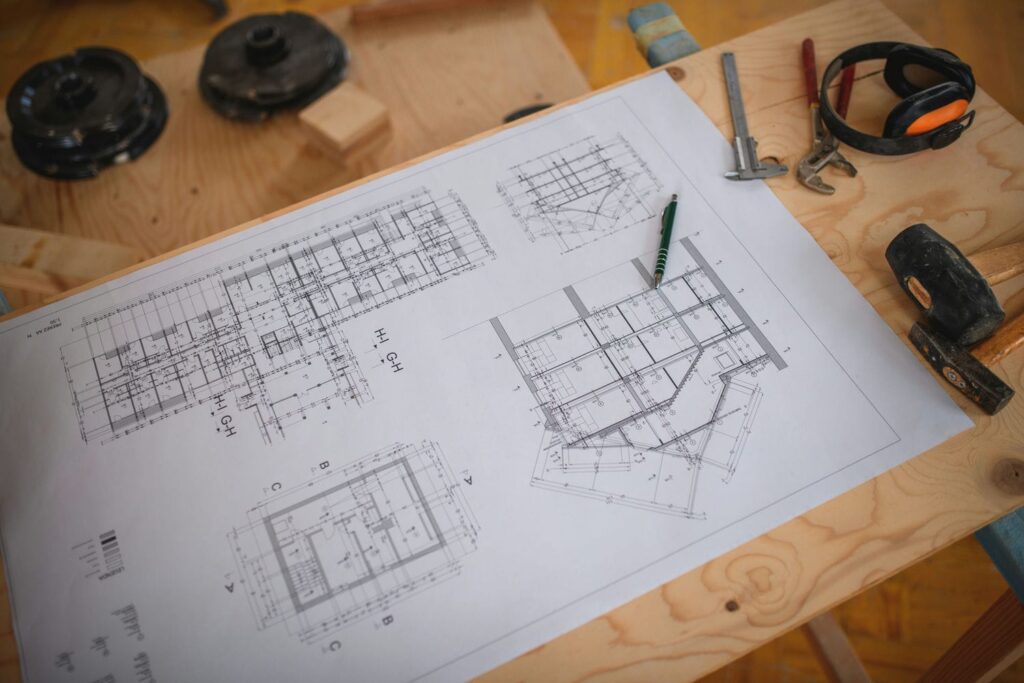 Structural drawings and tools laid out for review on a custom home jobsite before framing begins