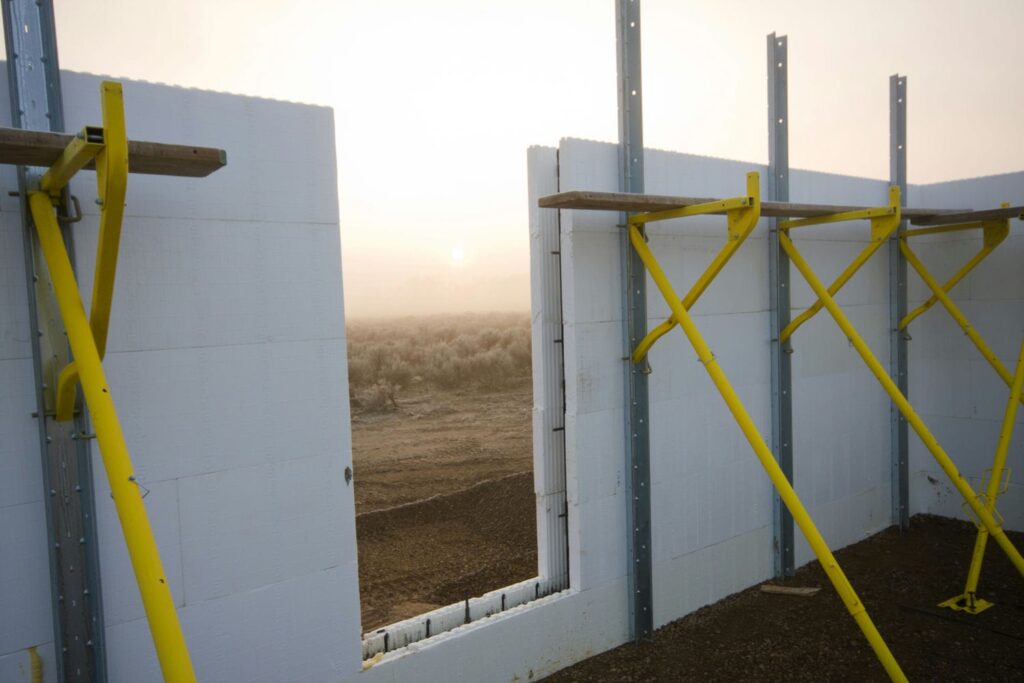Concrete foundation wall forms and panels set up on a custom home site representing the forming timeline